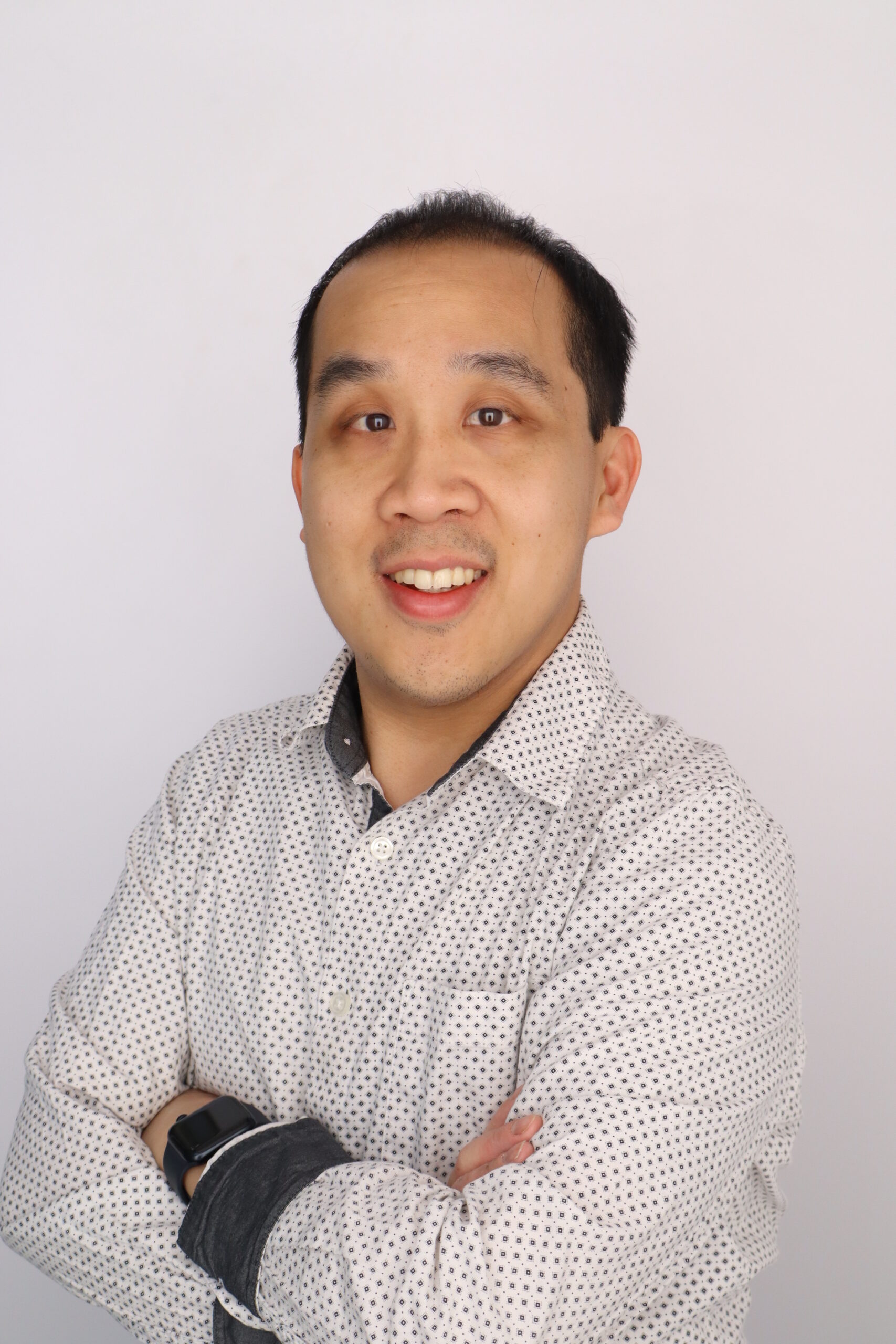 Greg Siering poses for a headshot. He wears a blazer and tie.